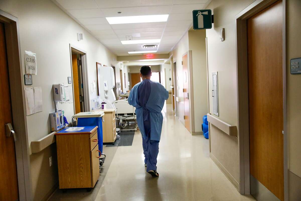 Nurse Nestor Cardenas walks down the hall as he treats COVID-19 patients at Regional Medical Center in San Jose.