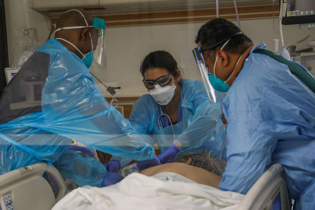 Nurse Waymond Jones (left) Respiratory Therapist Laura Sandoval (center) and nurse Larry Ngiraswei (right) prepare to prone a COVID-19 patient in the ICU at Regional Medical Center of San Jose, an acute-care hospital, on Tuesday, Dec. 8, 2020 in San Jose, California. Following Thanksgiving there has been an uptick in COVID-19 cases all over California and the Bay Area.