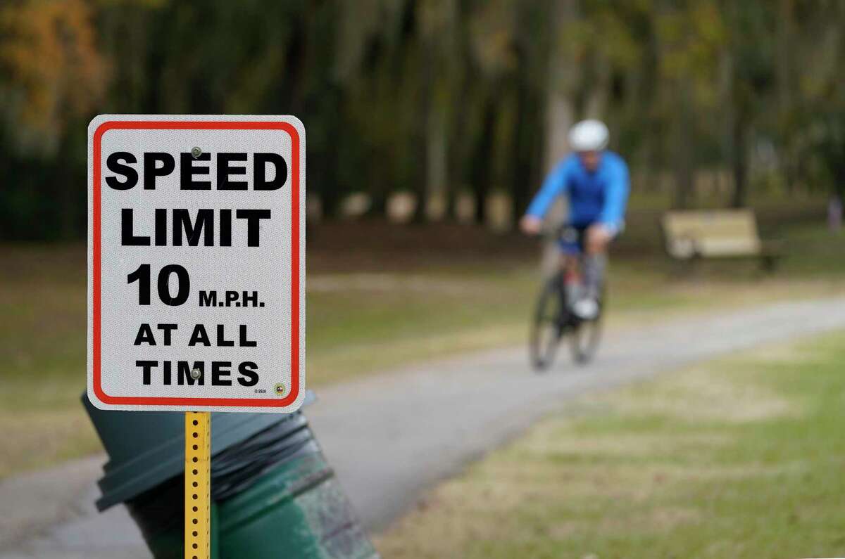 A bicyclist rides past a speed limit sign in Terry Hershey Park on Dec. 11, 2020 in Houston. Precinct 3 installed speed limit signs in George Bush and Terry Hershey Park and says they will enforce them for the trails. The 10 mph speed limits are needed, county officials said, because of complaints about cyclists on park pathways where there is pedestrian activity.