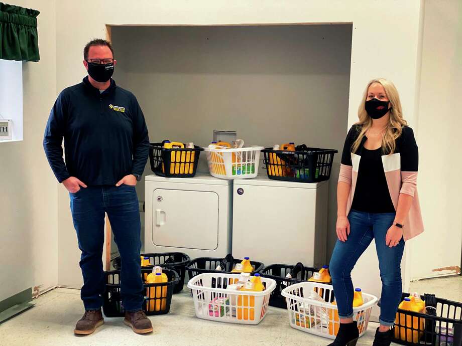 Chris Moultrup of Three Rivers Corporation and Kayley Lyons of DuPont pose for a photo with the newly installed washer and dryer. (Photo provided/DuPont)