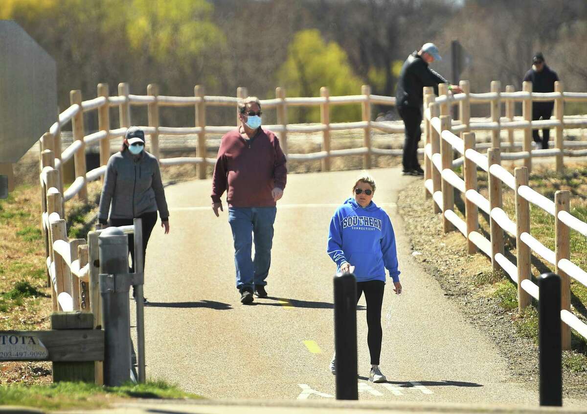 Walkers enjoy the sunny weather on the Derby Greenway section of the Naugatuck River Greenway in Derby, Conn. on Monday, April 6, 2020. The Ansonia section of the Greenway, called the Ansonia Riverwalk, has been closed due to social distancing concerns during the coronavirus pandemic. Members of the Northwest Hills Council of Governments endorsed the completed Naugatuck River Greenway Thomaston to Torrington Routing Feasibility Study Report this week, taking another step toward providing residents with a recreational opportunity for the future.
