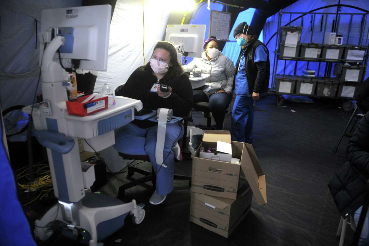 Medical personnel conduct the daily drive-thru COVID-19 testing at Bridgeport Hospital, in Bridgeport, Conn. Dec. 9, 2020.