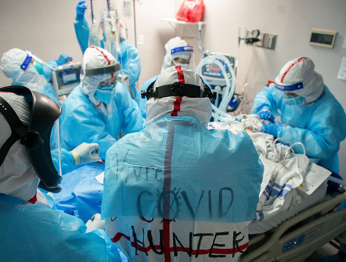 Dr. Joseph Varon, center, and his staff work to perform an intubation on a patient who went into cardiac arrest at the COVID Intensive Care Unit of United Memorial Medical Center, on Friday, Dec. 11, 2020, in Houston. As thousands of health care workers at Houston's largest hospitals will be first in line to receive the new COVID-19 vaccine in the coming days, those at smaller institutions, including UMMC will get none.