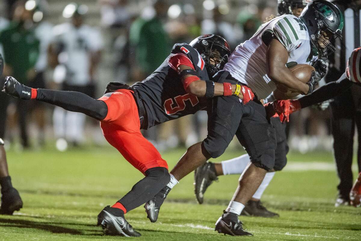 Titans Maleek Jones (5) latches onto the Hurricanes Charles Shelling (22) and refuses to let go in the second quarter. The Port Arthur Titans battled with the Fort Bend-Hightower Hurricanes in bi-district football playoff action Friday night. Photo made on December 11, 2020. Fran Ruchalski/The Enterprise