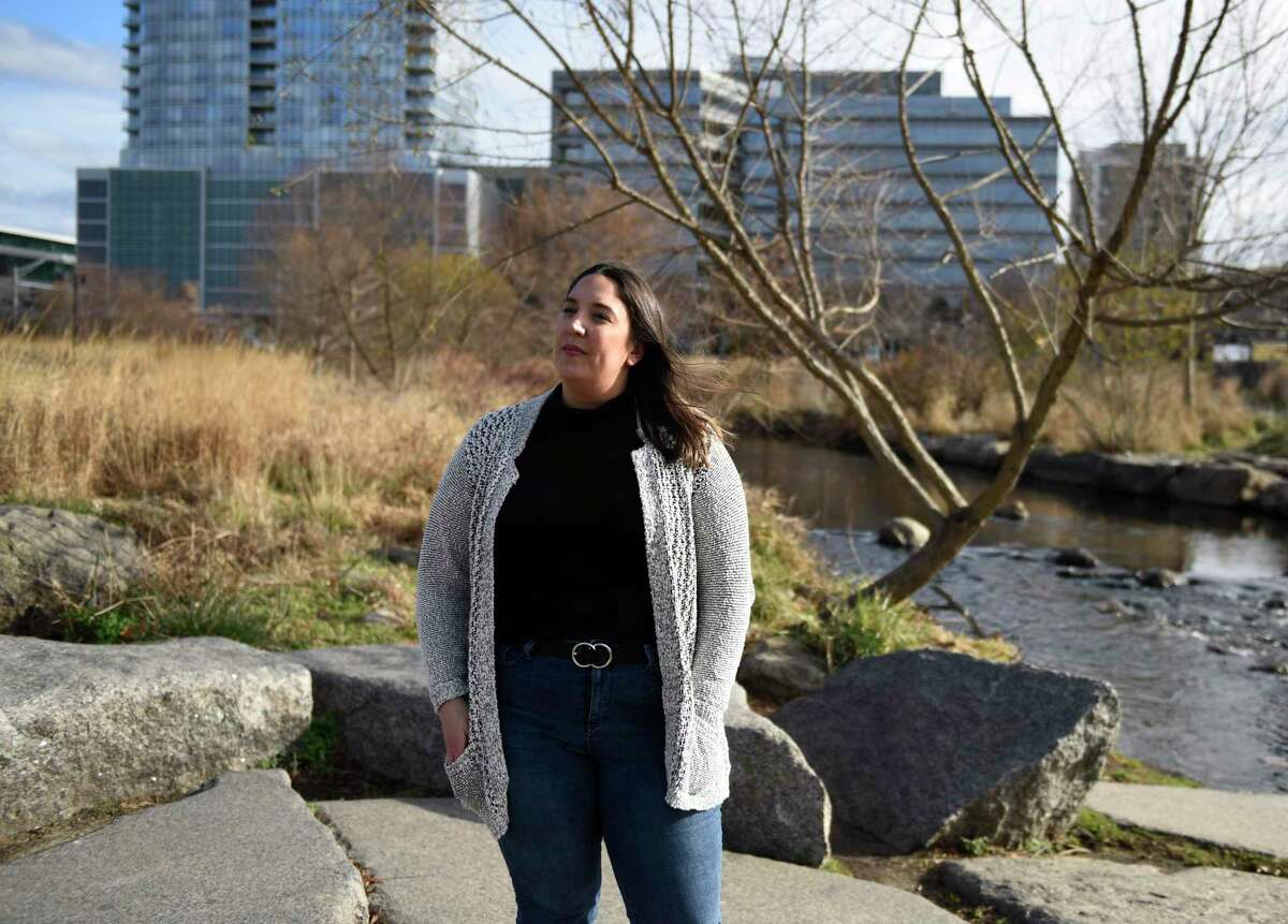 Stamford resident Samantha Chiafalo poses at Mill River Park in Stamford, Conn. on Tuesday, Dec. 8, 2020. Chiafalo noticed the stone while walking her dog through the park and has launched a petition calling for the Mill River Park Collaborative to remove the stone and denounce the company.