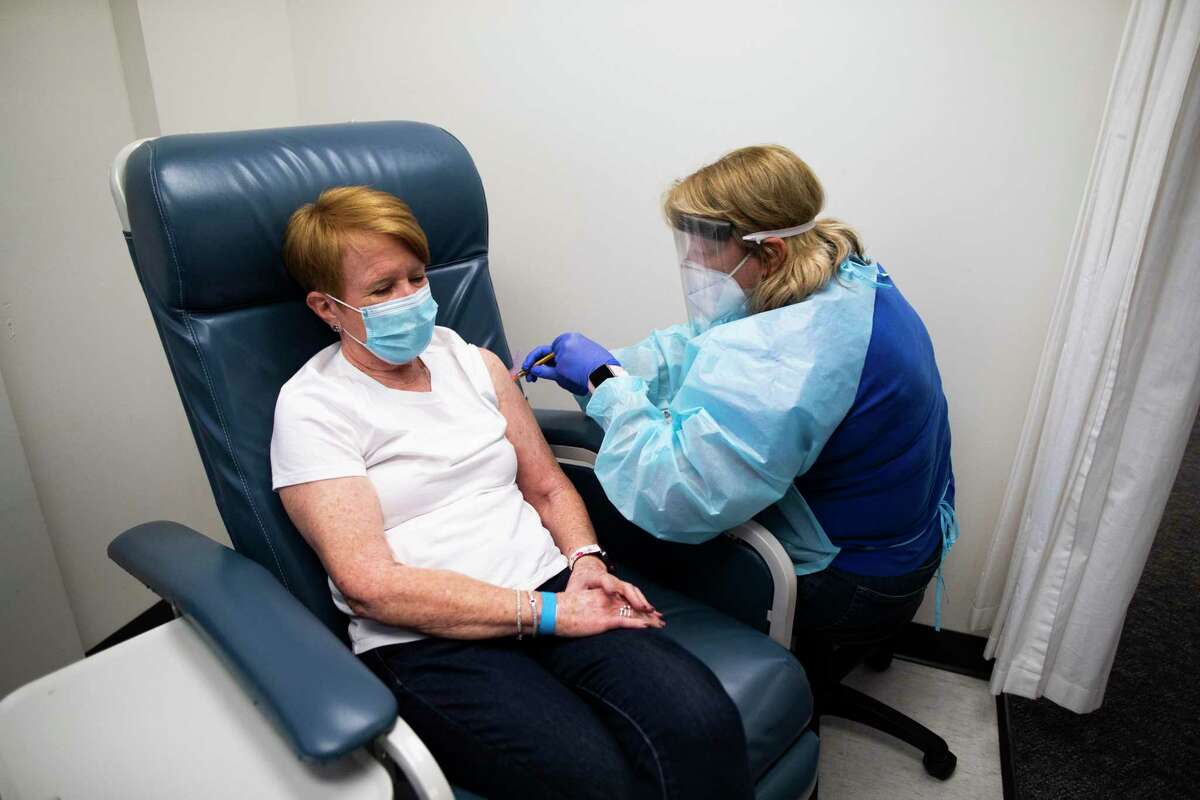 Linda Lamberth, left, 66, participates in a double blind trial which entails getting an experimental vaccine for COVID-19 at the Baylor College of Medicine on Friday, Aug. 7, 2020, in Houston. Lamberth gets the vaccine from Annette Nagel, a research nurse Baylor College of Medicine. The vaccine is on Phase III in the trial by the vaccine made by Moderna.