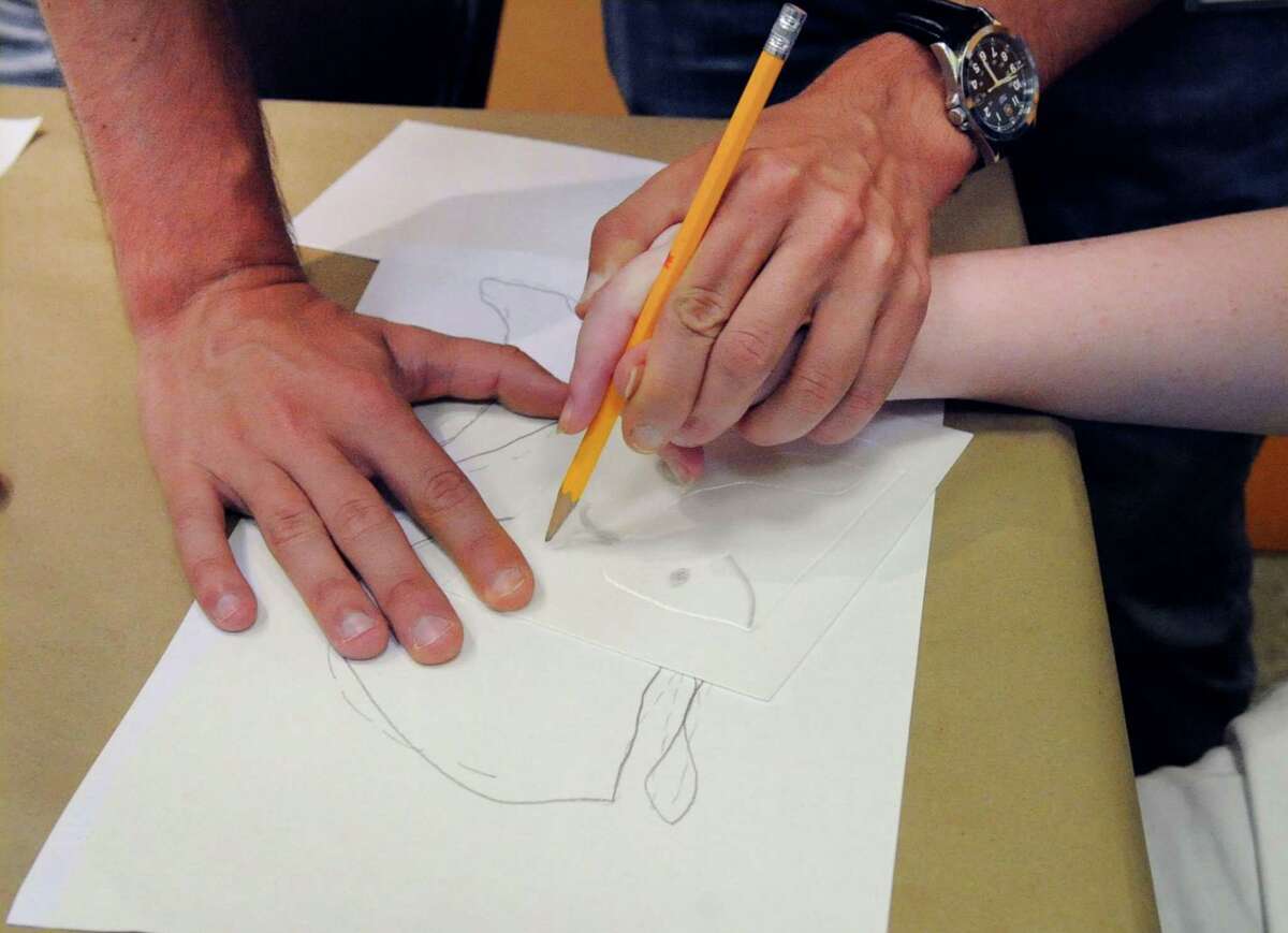 A student is taught by an educator during an art class in Connecticut during a previous summer season. Here is information about what is happening in Ridgefield from a virtual storytime event, a virtual wellness fair, and drawing and art history courses.