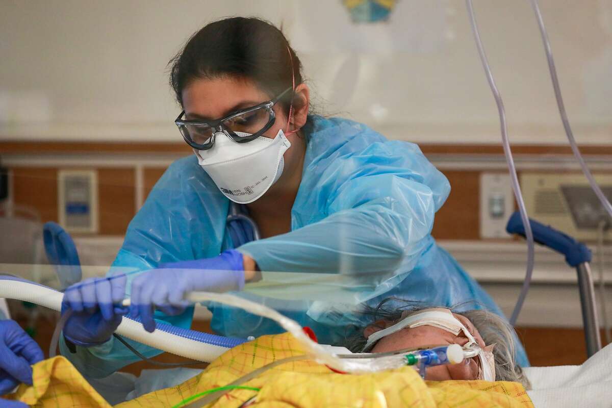 Respiratory Therapist Laura Sandoval adjusts breathing tubes on a COVID-19 patient in the ICU at Regional Medical Center in San Jose. ICU capacity for the Bay Area region is 16.7%.