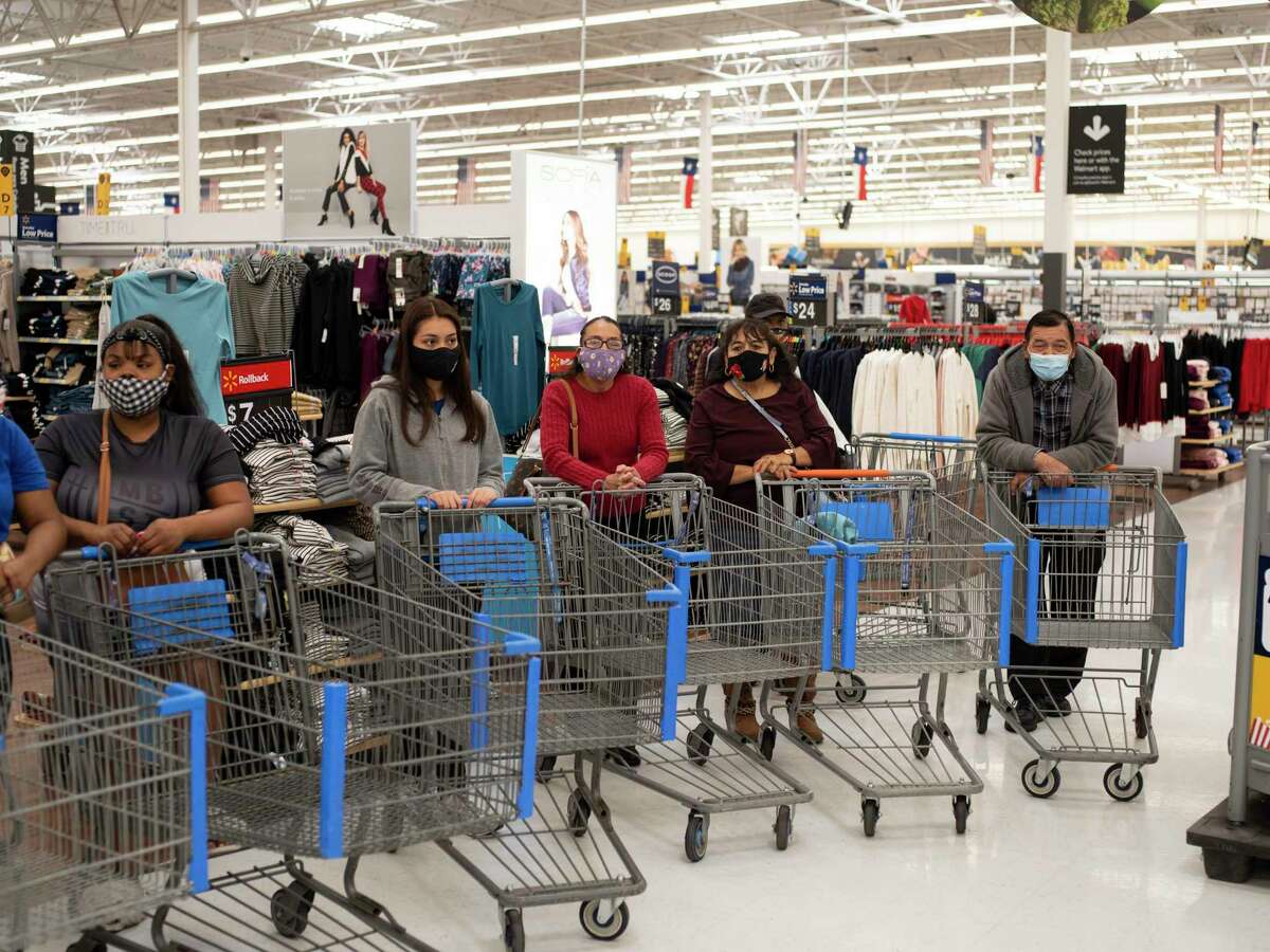 Families line up to participate in a Christmas shopping spree sponsored by Milas Williams’ nonprofit World Lolei where each family was given $1,000 to use at Walmart on Saturday, Dec. 12, 2020, in San Antonio.