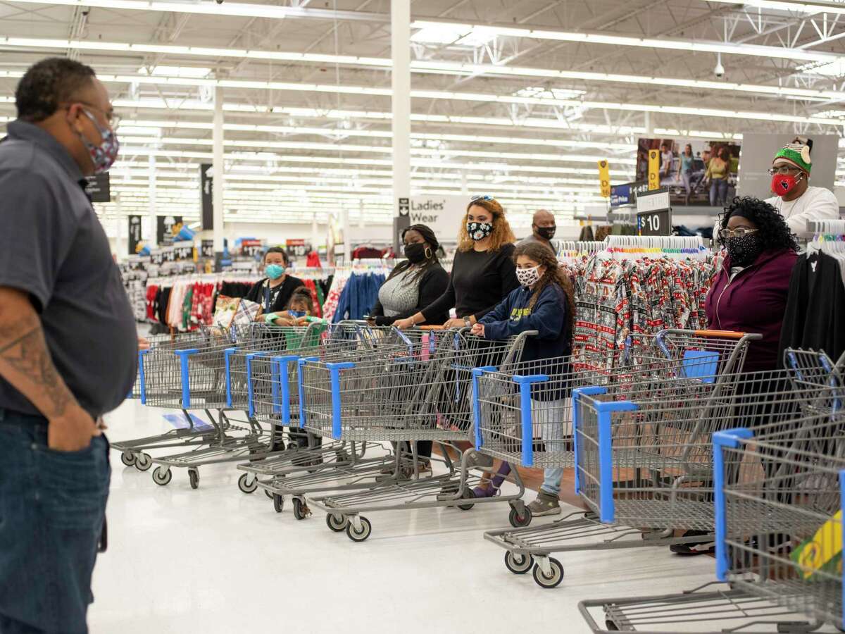 Milas Williams, founder of the nonprofit World Lolei, left, speaks to 10 families who each received a $1,000 shopping spree at Walmart on Saturday, Dec. 12, 2020, in San Antonio.
