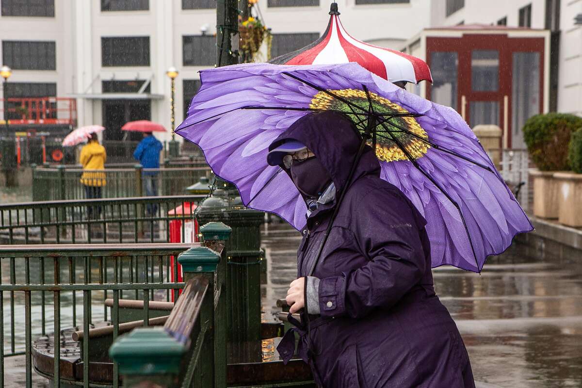 Elise Everett braves the rain on Sunday, December 13, 2020 in San Francisco, Calif. The Bay Area anticipates renewed showers ahead of the weekend.