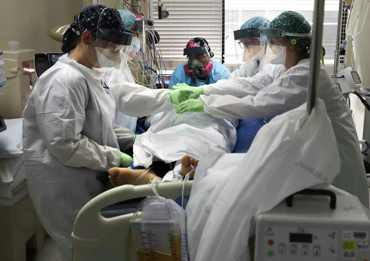 A team of nurses works to turn a patient to the stomach in order to breathe easier in the COVID-19 ICU unit at University Medical Center in Lubbock on Wednesday, Dec. 9, 2020.