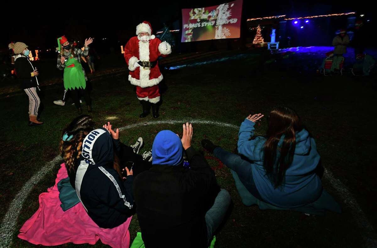 Santa, aka Joseph Hofflinger, greets familes as Celebrate Shelton holds its seventh annual community tree lighting Friday, December 11, 2020, at the Rotary Pavilion at Veteran’s Memorial Park in Shelton, Conn. In addition to the tree lighting and the visit from Santa and Mrs. Claus, the event featured an ice sculpture demonstration by Ice Matters; a fire dance performance with Sarotonin Performance Arts; and a holiday dance party. The community tree lighting was sponsored by the city, Center Stage Theatre, Apple Rehab, Jones Family Farm, Echo Hose Hook & Ladder Co. 1 and Valley Community Foundation.