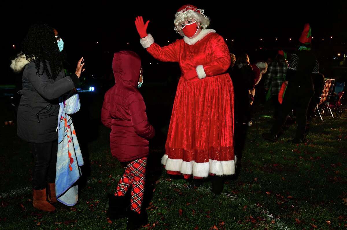Mrs. Claus, aka Colleen Roche, greets familes as Celebrate Shelton holds its seventh annual community tree lighting Friday, December 11, 2020, at the Rotary Pavilion at Veteran’s Memorial Park in Shelton, Conn. In addition to the tree lighting and the visit from Santa and Mrs. Claus, the event featured an ice sculpture demonstration by Ice Matters; a fire dance performance with Sarotonin Performance Arts; and a holiday dance party. The community tree lighting was sponsored by the city, Center Stage Theatre, Apple Rehab, Jones Family Farm, Echo Hose Hook & Ladder Co. 1 and Valley Community Foundation.