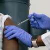Sandra Lindsay, left, a nurse at Long Island Jewish Medical Center, is inoculated with the Pfizer-BioNTech COVID-19 vaccine by Dr. Michelle Chester, Monday, Dec. 14, 2020, in the Queens borough of New York.