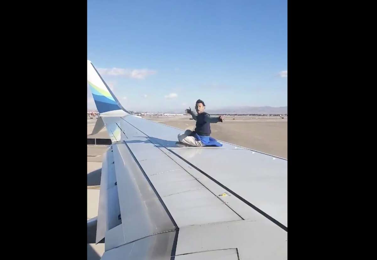 Police arrested a 41-year-old man shown on video walking on the wing of an Alaska Airlines flight preparing to depart from Las Vegas.