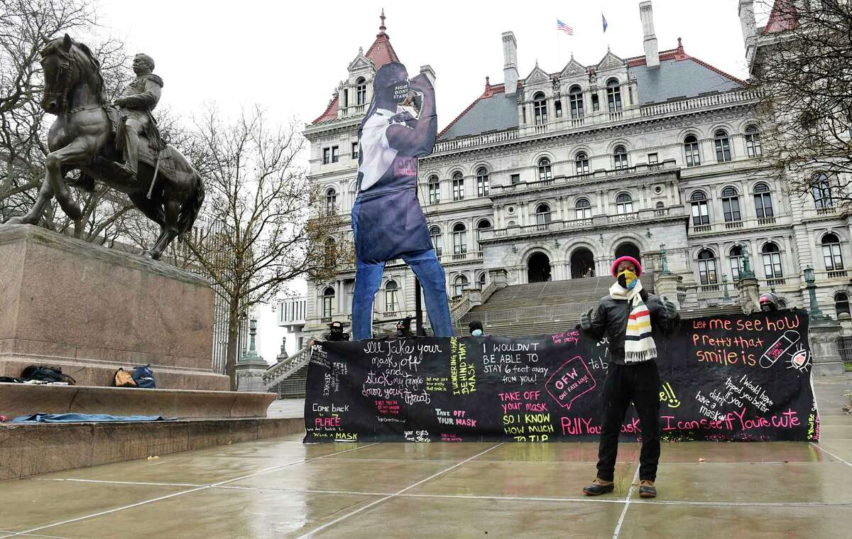 Restaurant industry worker Damani Varnado of Brookyln speaks during a rally at East Capitol Park demanding One Fair Wage on Monday, Dec. 14, 2020 in Albany, N.Y. The restaurant workers were holding a banner displaying some of the sexual harassment quotes they receive from some of their customers. Elena the Essential Worker, a 24-foot statue reminiscent of the famous Rosie the Riveter icon is seen behind them. (Lori Van Buren/Times Union)