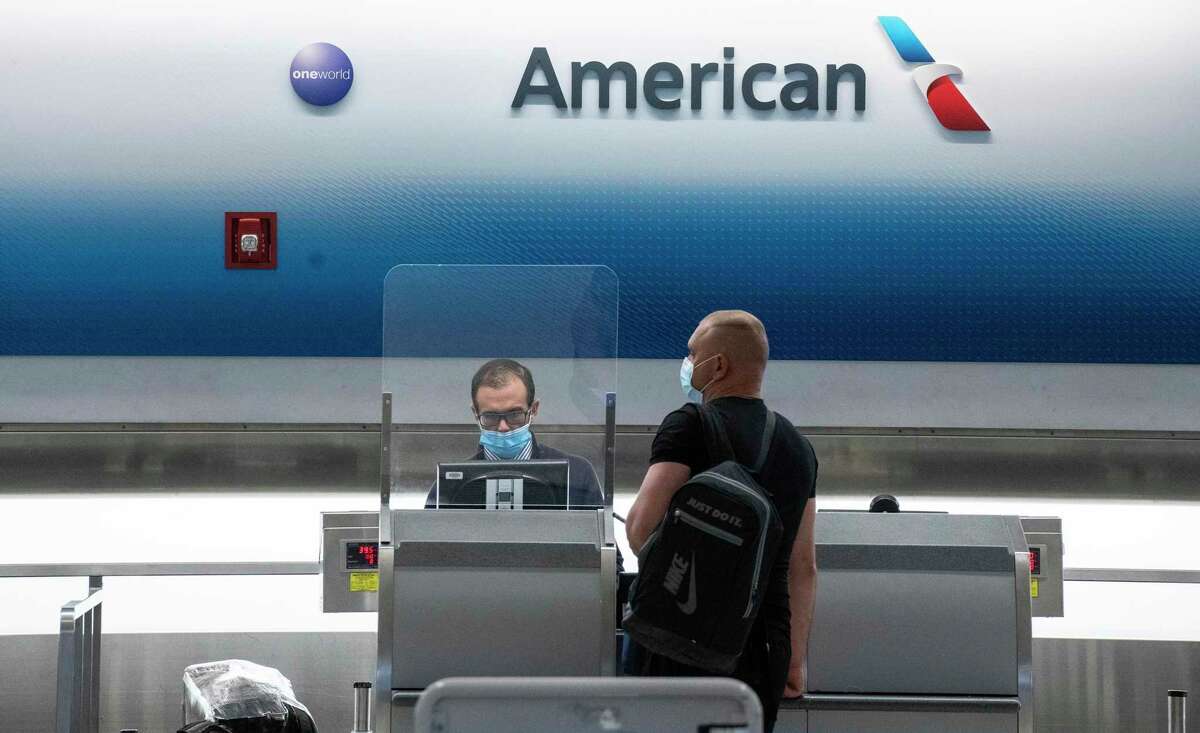 An American Airlines employee assists a traveler at Miami International Airport.
