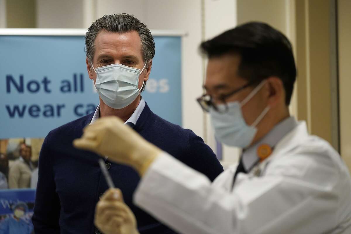 California Gov. Gavin Newsom watches as the Pfizer-BioNTech COVID-19 vaccine is prepared by Director of Inpatient Pharmacy David Cheng at Kaiser Permanente Los Angeles Medical Center in Los Angeles, Monday, Dec. 14, 2020. (AP Photo/Jae C. Hong)