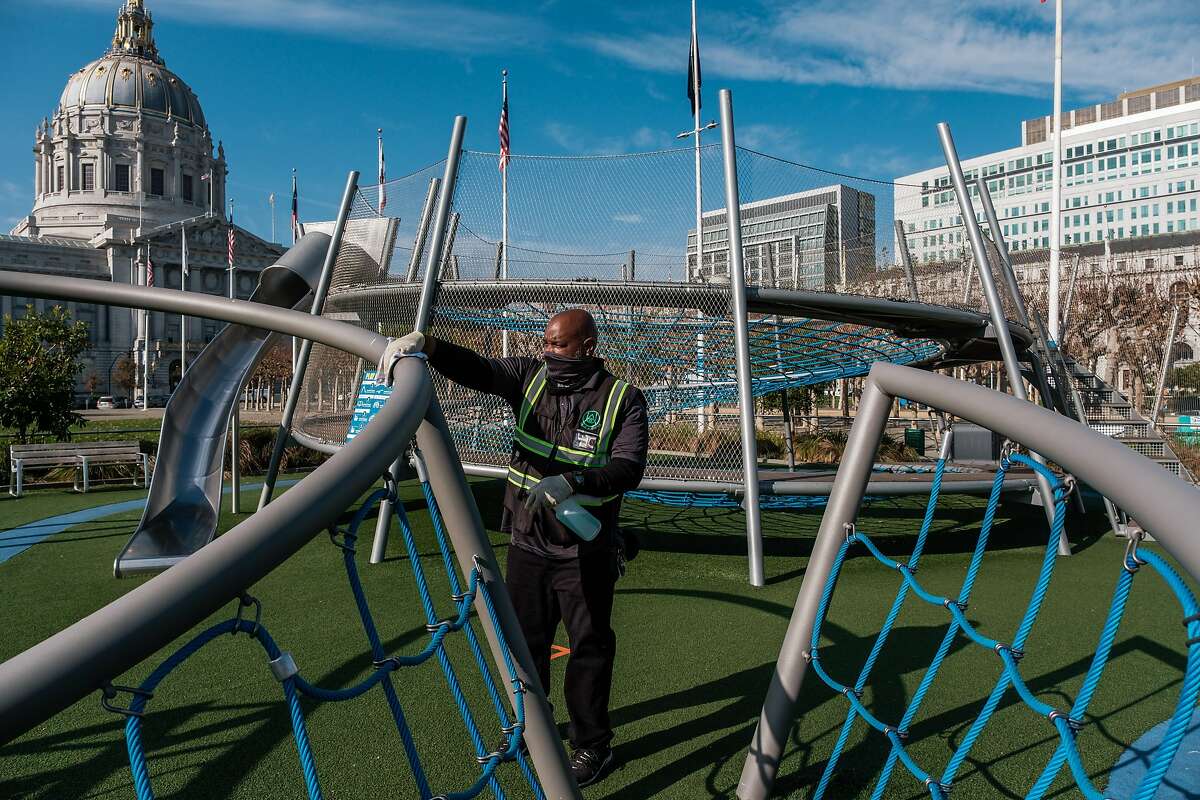 Perry Lennon with Urban Alchemy cleans the Civic Center playground in San Francisco on Wednesday, Dec. 9, 2020, the day Mayor London Breed announced playgrounds would reopen to the public.