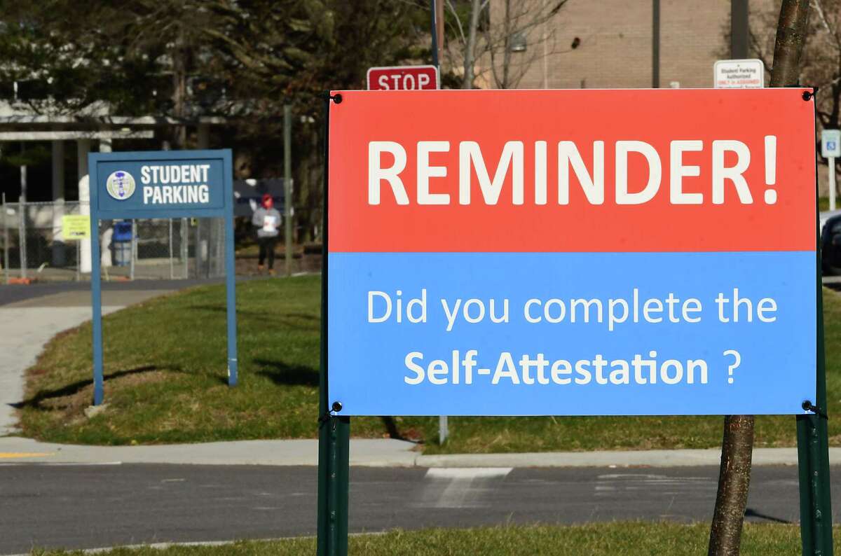 A reminder sign for completion of COVID-19 self-attestation is seen upon entering Shaker High School on Tuesday, Dec. 15, 2020 in Colonie, N.Y. More districts announced they are shifting entirely to remote learning until January. (Lori Van Buren/Times Union)