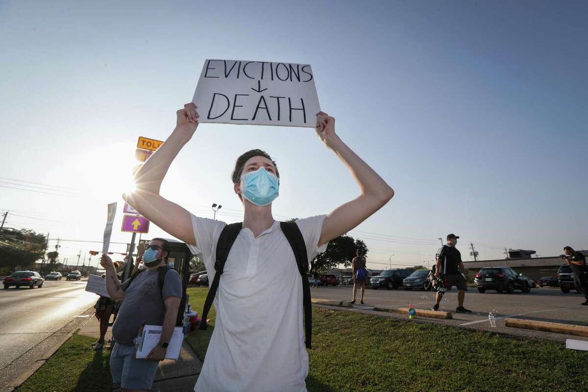 Ian Druke holds a sign during a protest regarding evictions going on at the court, 6000 Chimney Rock Rd., Friday, Aug. 21, 2020, in Houston.