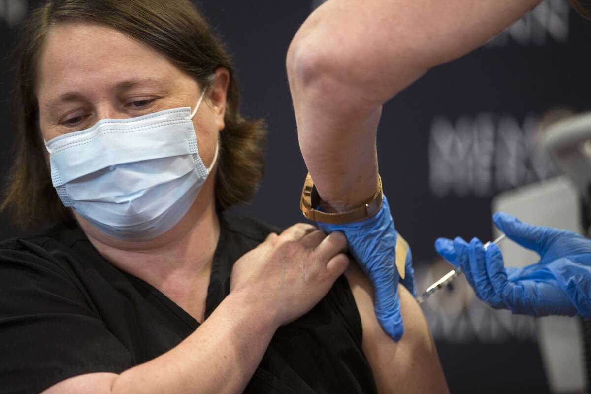 Dr Linda Yancey, infections disease specialist, receives a dose of the Pfizer Covid-19 vaccination from Mindy Warren Tuesday, Dec. 15, 2020 in Houston. A group of front line medical workers at Memorial Hermann Hospital were some of the first to receive the recently approved vaccine. The Pfizer vaccine was almost 95 percent effective at preventing patients from contracting COVID-19 and caused no major side effects in a trial of nearly 44,000 people.