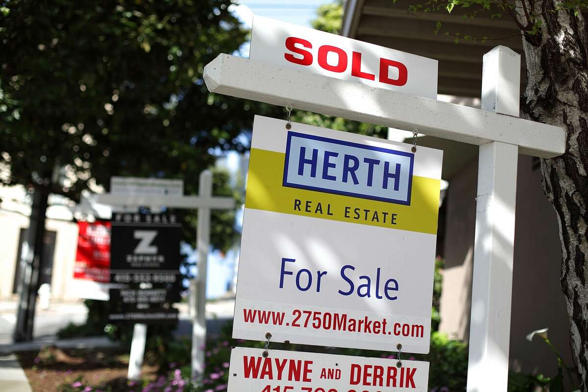 In this file photo, real estate signs are posted in front of homes for sale in San Francisco.