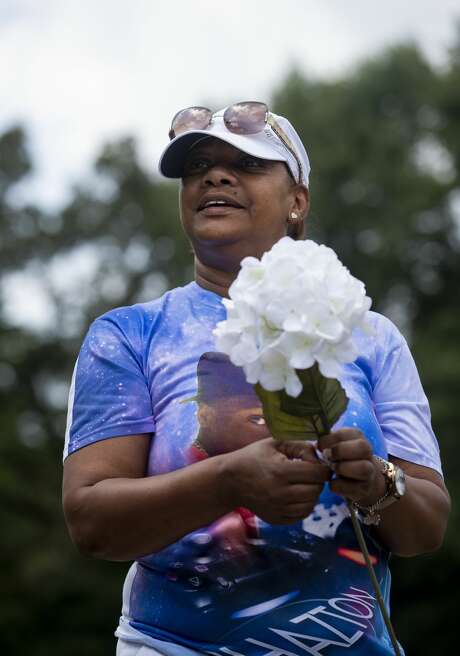 Daphne Nelson carries artificial flowers to lay at her son's grave. Photo: Godofredo A. Vásquez, Staff Photographer / © 2020 Houston Chronicle