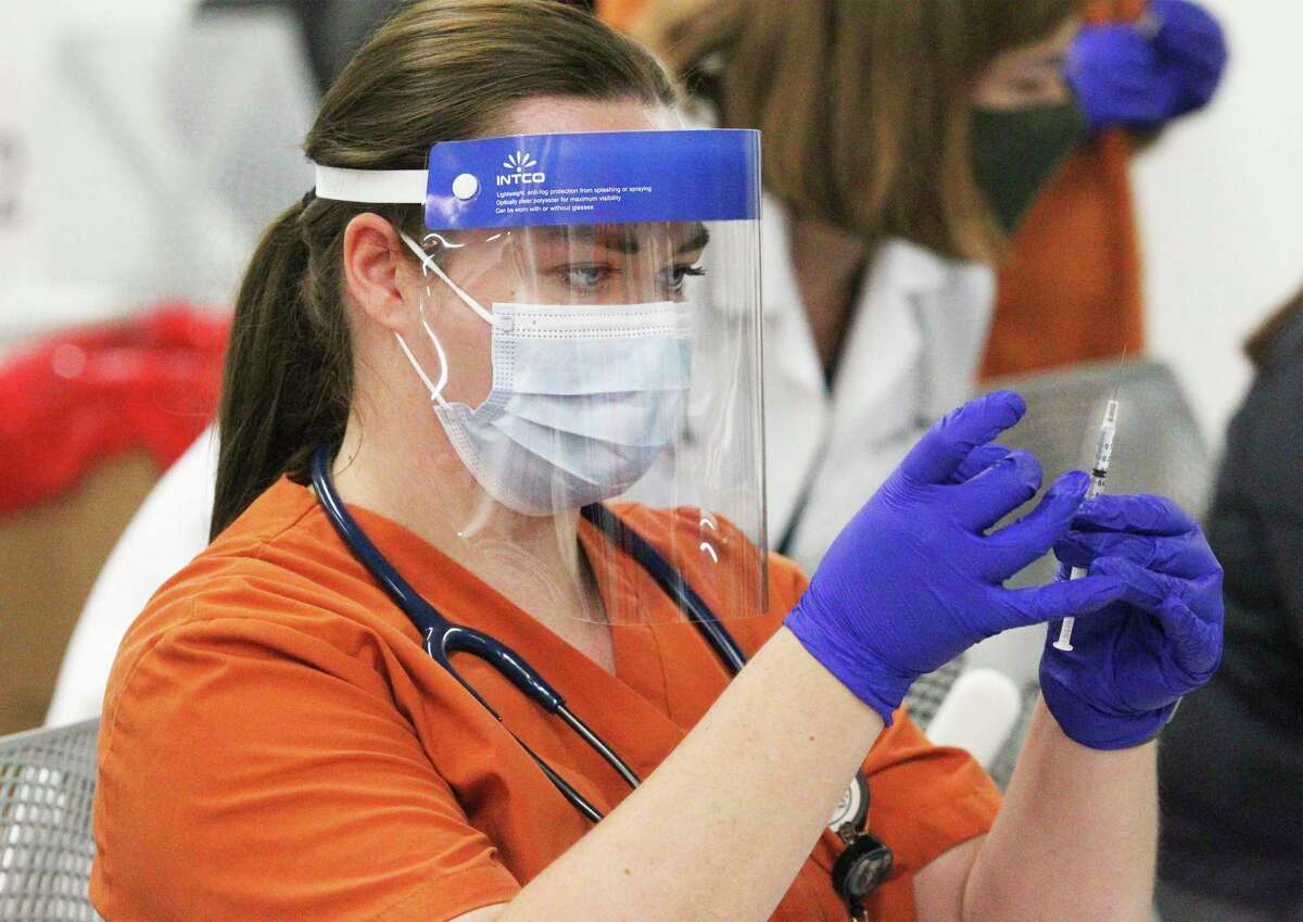 Kendra Mack-Semler draws a dose of vaccine as UT Health San Antonio administers the first doses of Pfizer's COVID-19 vaccine with frontline healthcare members receiving shots on Dec. 15, 2020.