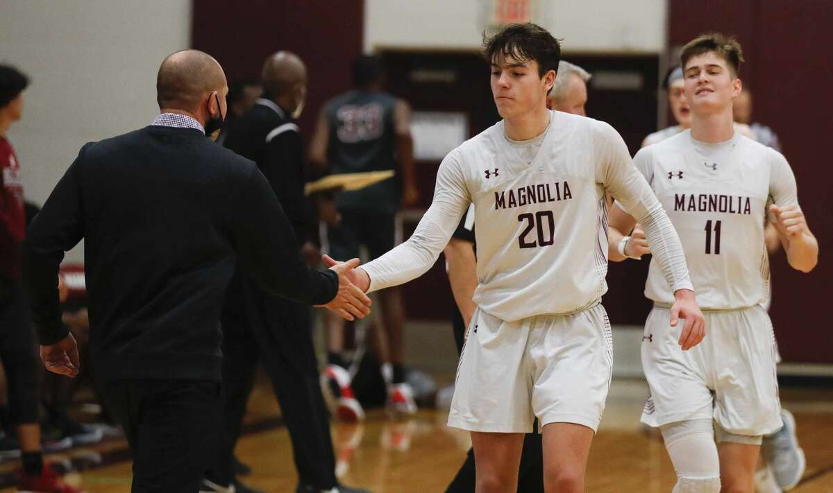 Magnolia guard Mason Machado (20) gets a high-five from head coach Derek Cain after making three straight freethrows with 1.43 seconds remaining to give the Bulldogs a 54-51 win over Waller during a high school basketball game at Magnolia High School, Tuesday, Dec. 15, 2020, in Magnolia.