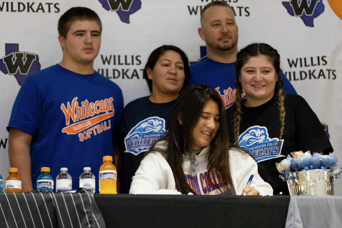 Marissa Fletcher, who signed with Galveston College's softball team, signs alongside her family during a National Signing Day ceremony at Willis High School, Wednesday, Dec. 16, 2020, in Willis.