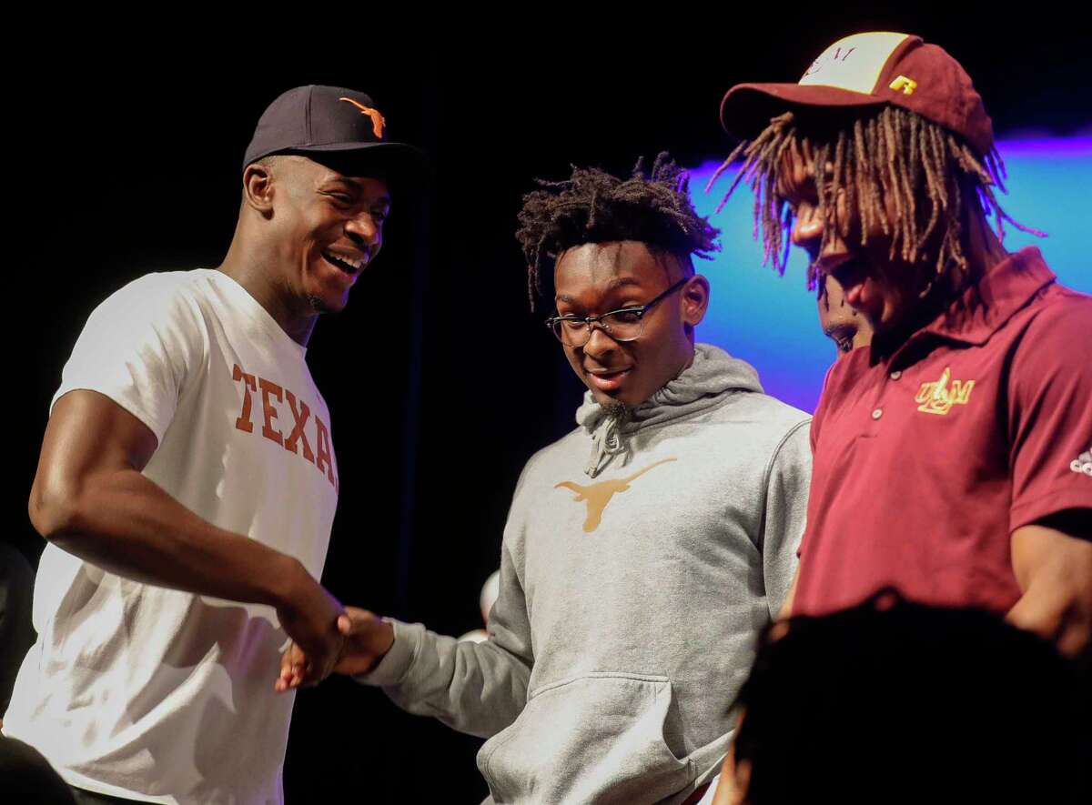 New Caney’s Derrick Harris, Jr. (left) laughs beside Orian Wormley after signing to play football for the University of Texas during a signing ceremony at New Caney High School, Wednesday, Dec. 16, 2020, in New Caney.