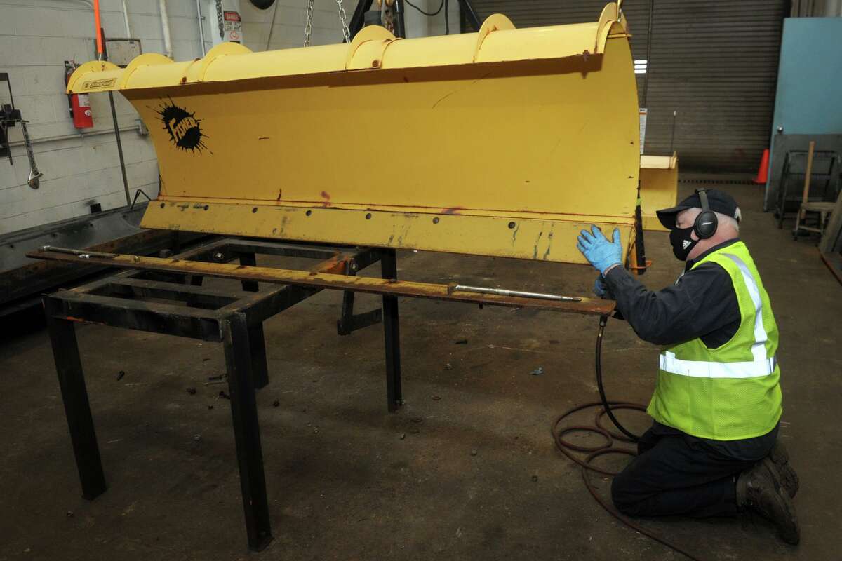 Sal Cicale works to prepare a snowplow with a new blade in the Town of Fairfield’s department of public works garage, in Fairfield, Conn. Dec. 16, 2020.