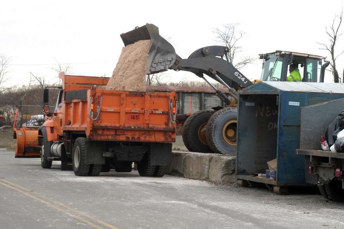 A payloader fills a waiting truck with salt outside the Town of Fairfield’s department of public works garage, in Fairfield, Conn. Dec. 16, 2020.