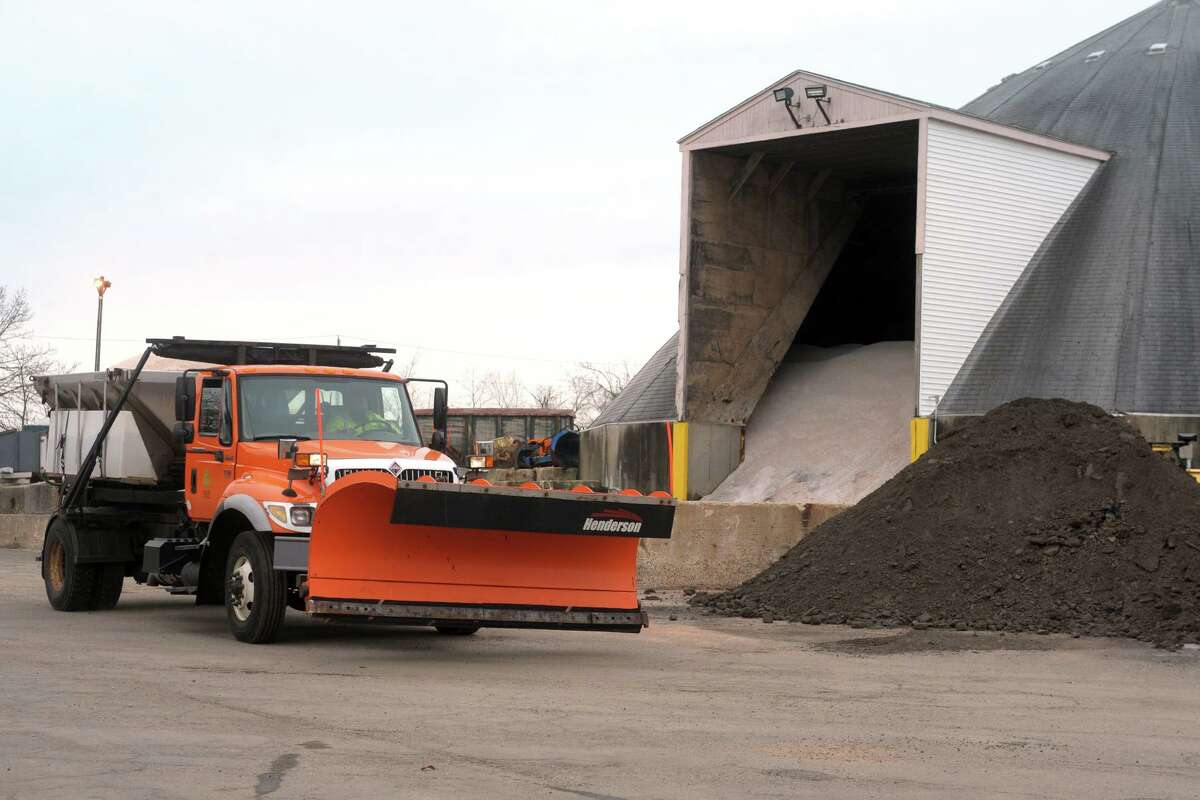 A truck with a full load of salt drives past the salt barn outside the Town of Fairfield’s department of public works garage, in Fairfield, Conn. Dec. 16, 2020.
