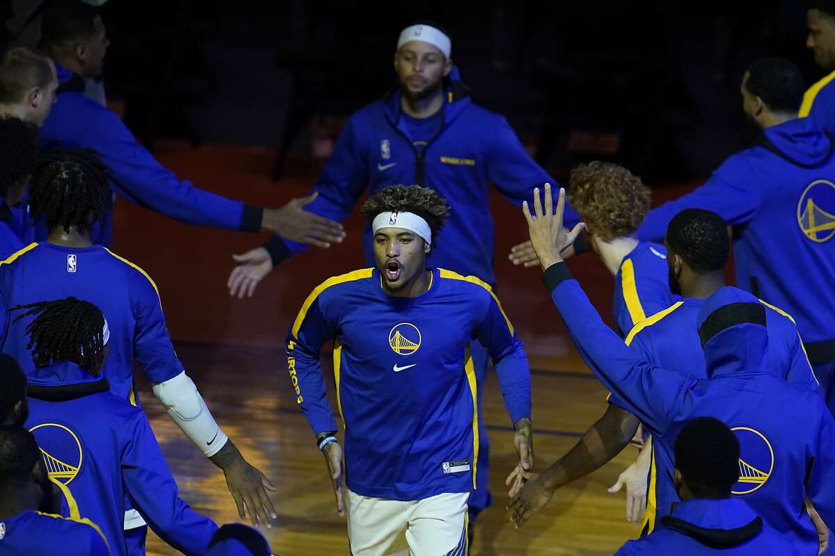 Golden State Warriors forward Kelly Oubre Jr., bottom, is introduced in front of Stephen Curry before a preseason NBA basketball game against the Denver Nuggets in San Francisco, Saturday, Dec. 12, 2020.