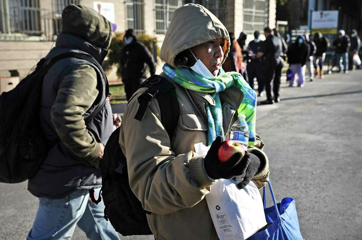 Maria Torres, 50, carries her sack meal she received from Christian Assistance Ministry, on Wednesday, Dec. 16, 2020. The City Council will be reviewing the city's 5-year plan to reduce homelessness.