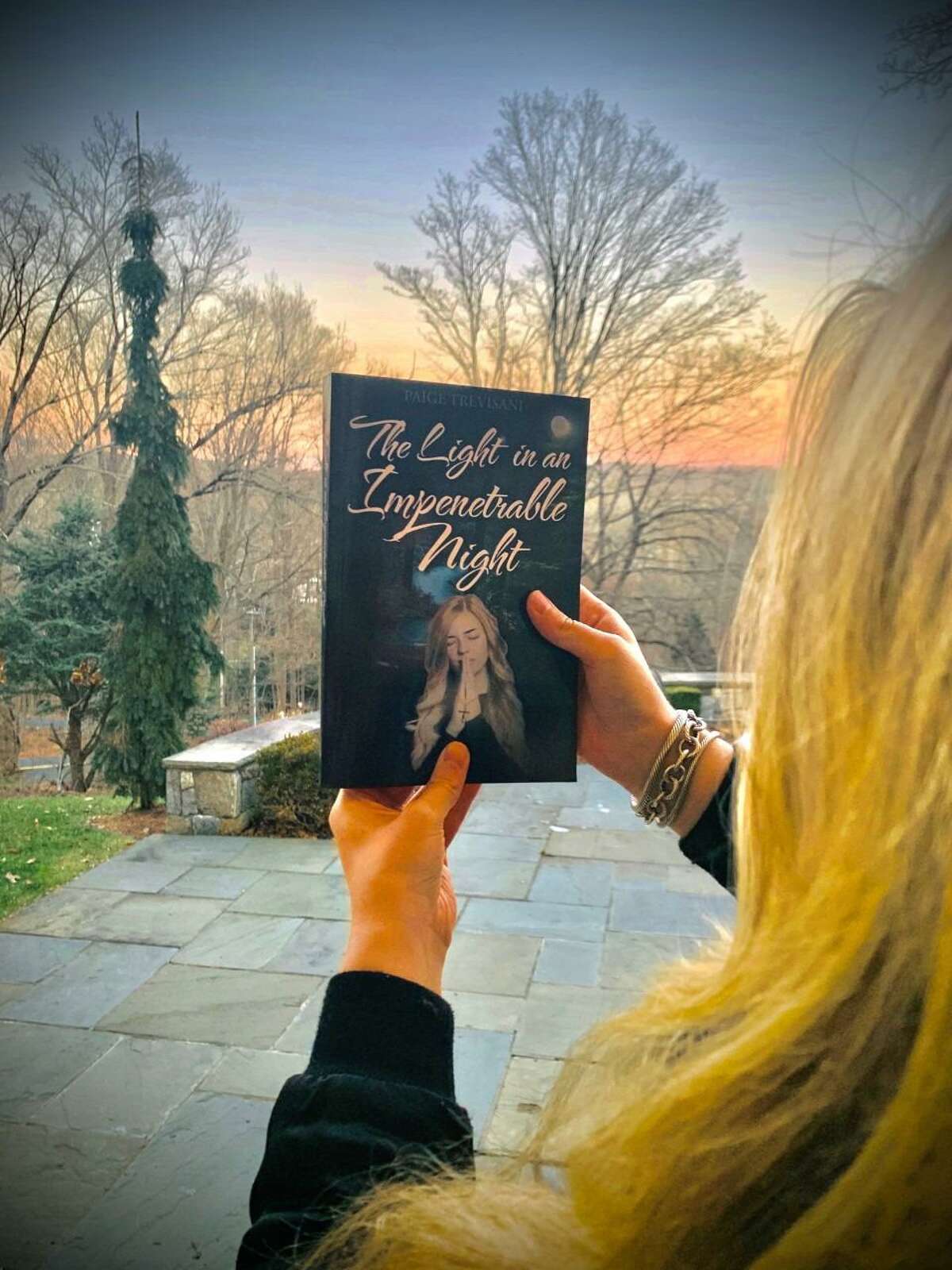 Julie Trevisani's daughter, Paige Trevisani who grew up in Ridgefield, holds a book she has published titled: