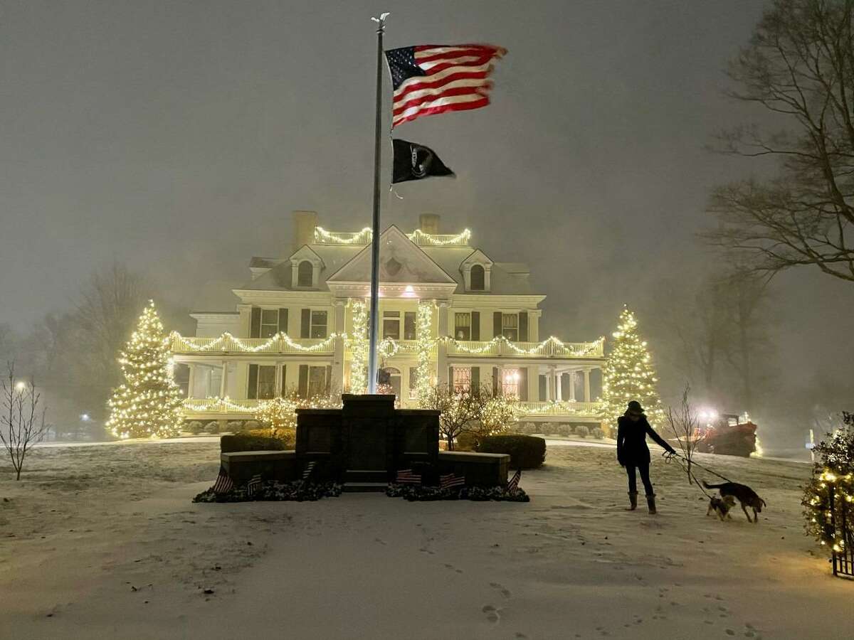The first snowstorm of the late 2020 colder weather season is just kicking in at 7:21 p.m. Wednesday evening Dec.16, 2020, for Kevin Elston's wife Deirdre Elston and their dogs Calvin and Daisy by the Lounsbury House in Ridgefield.