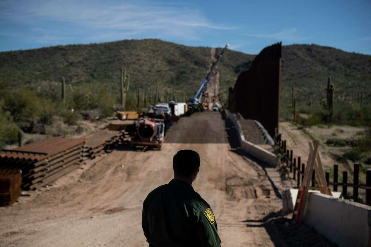 Border Patrol agent Joe Curran looks at fence construction in the Organ Pipe Cactus National Monument in Lukeville, Ariz. in January 2020.