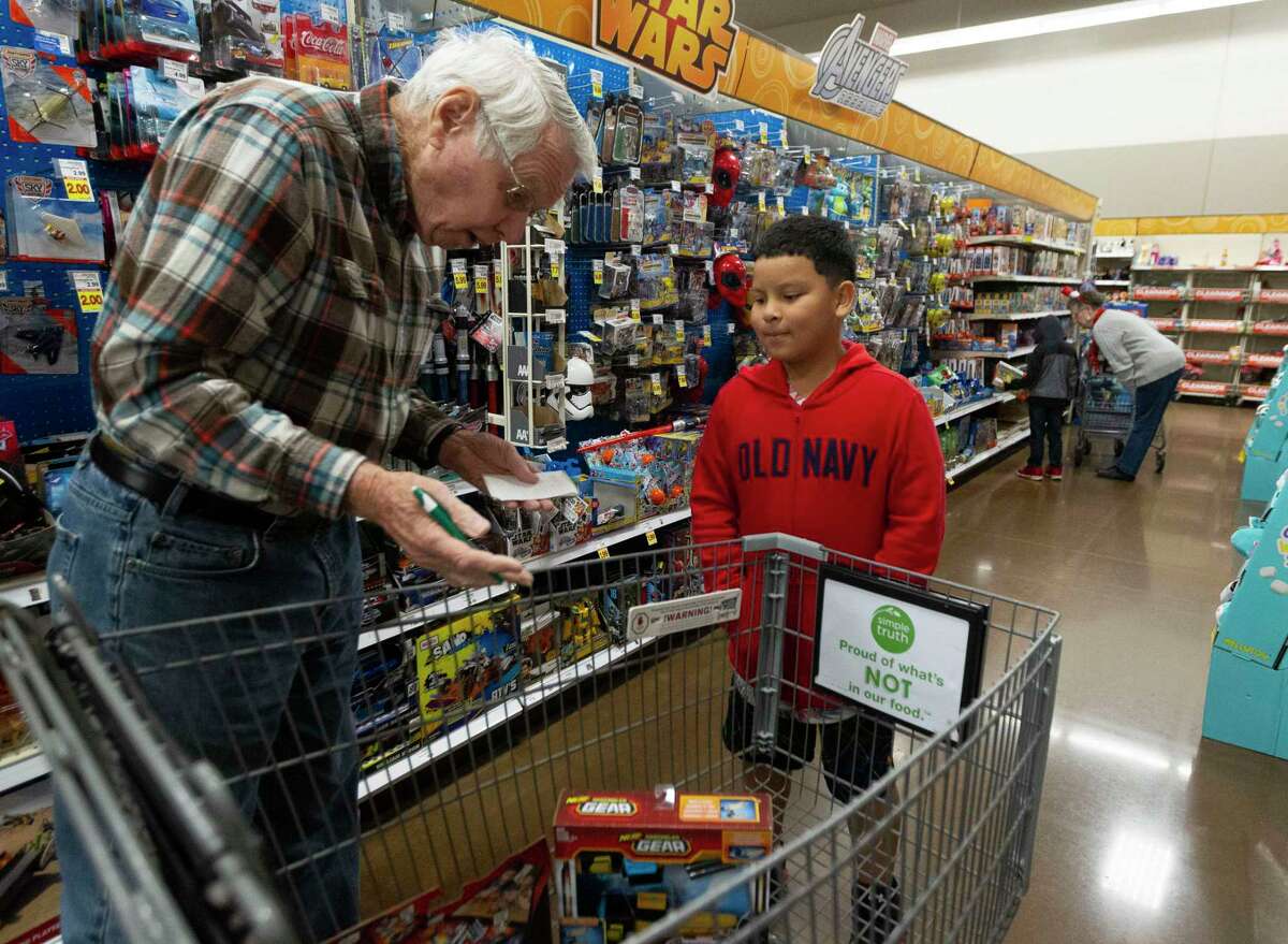 Max Martensen helps Bryan Navarrete, 10, check how much money he has left during the annual Panorama Samaritans shopping event at Kroger, Saturday, Dec. 21, 2019, in Willis. The annual event allowed 100 children from the area to choose Christmas presents to themselves and their family.