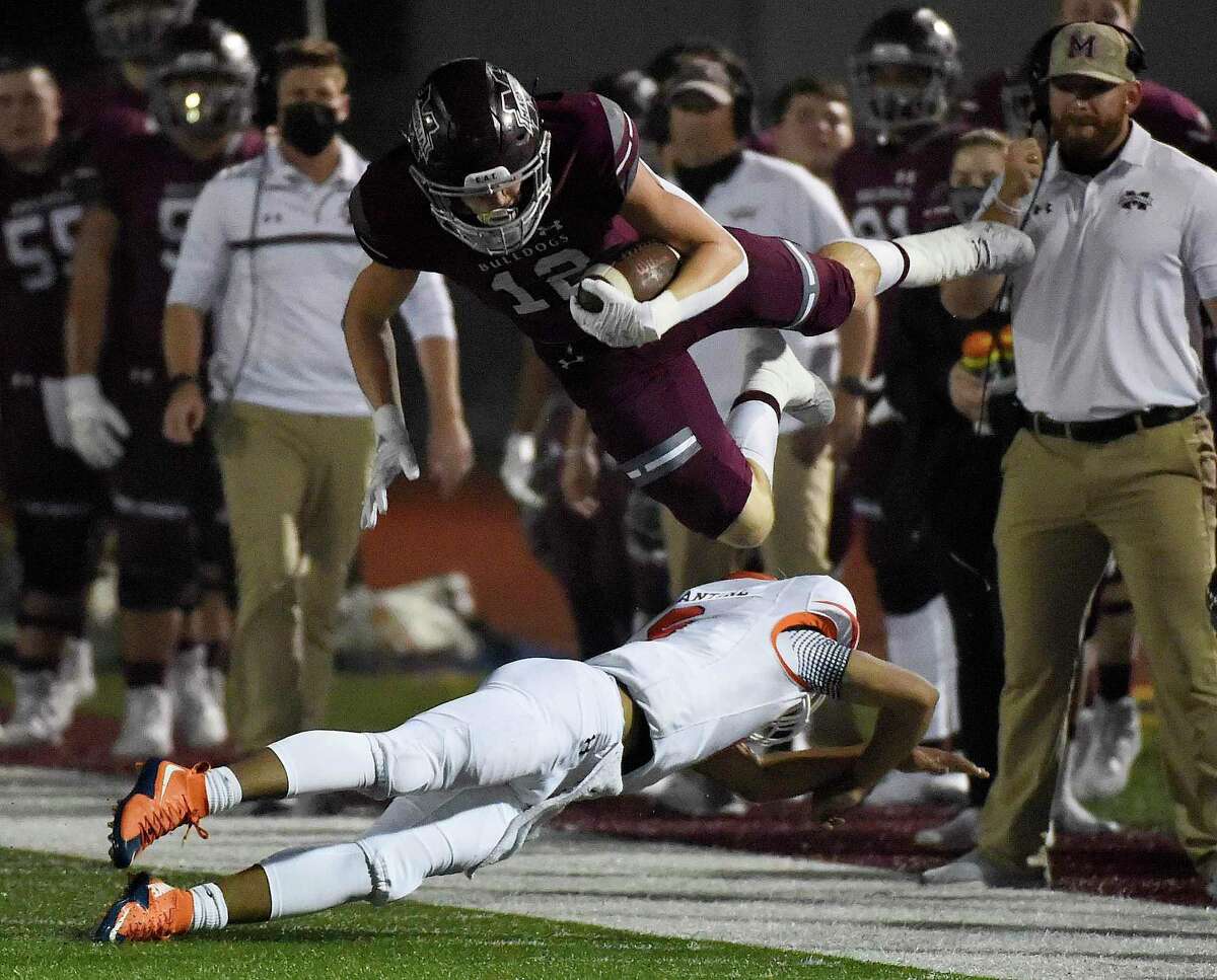 Magnolia kick rerturner Nathan Hakes, top, leaps over McKinney North’s Gavin Constatine during a punt return during the first half of a 5A Division I Region II bi-district high school football playoff game, Friday, Dec. 11, 2020, in Magnolia, TX.