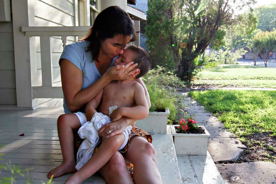 Liz Tullis comforts her son Conrad, 3, before bed on the porch of their Monte Vista home. Conrad nearly drowned as a toddler while under the care of his paternal grandfather. He suffered major brain damage and needs constant attention. Photo: NICOLE FRUGE, SAN ANTONIO EXPRESS-NEWS / SAN ANTONIO EXPRESS-NEWS