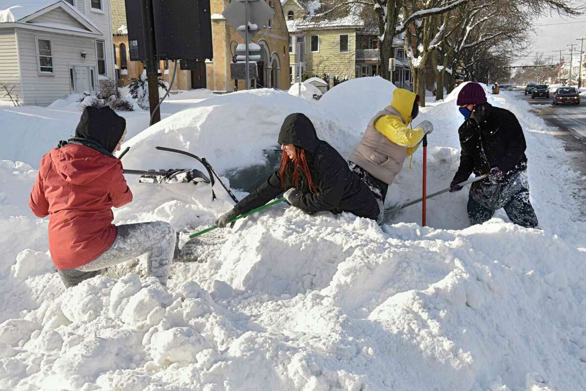 From left, Albany friends Emily McCord, Sara Eads, Alexis Desjarden and Kasey Palmer work on digging out Alexis' car on Madison Ave. after a nor'easter snow storm on Thursday, Dec. 17, 2020 in Guilderland, N.Y. The friends were going to tackle the next persons car afterwards. (Lori Van Buren/Times Union)