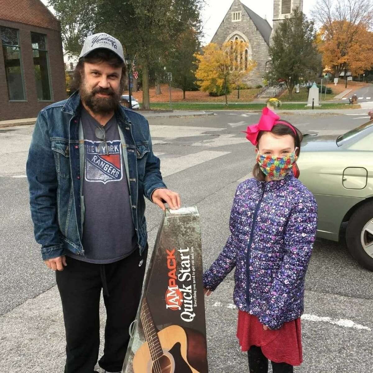 Vinny Rodriguez presents the gift of a guitar to a child.