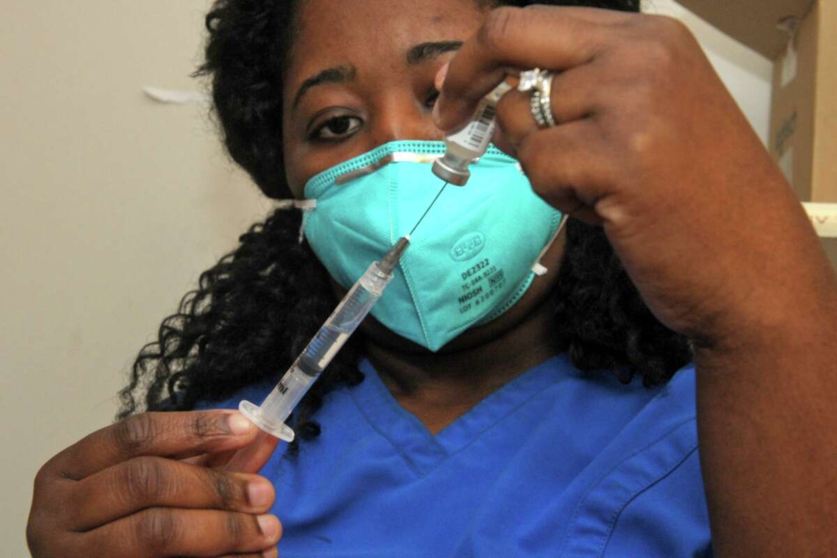 Nurse Daphney Hippolyte fills a syringe with a dose of the Pfizer COVID-19 at Stamford Hospital, in Stamford, Conn. Dec. 17, 2020.