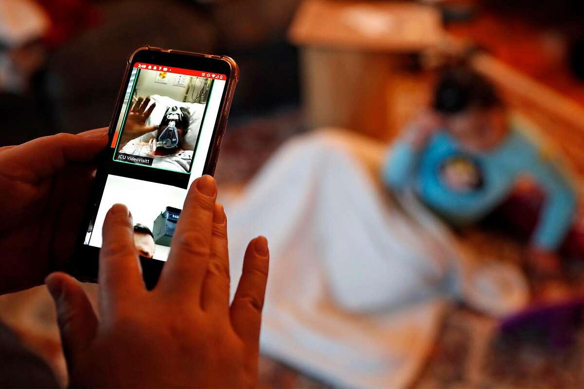 Verónica Hernández, looks at an image from a family call on Zoom of her uncle, José Jesús Arroyo, as he waves goodbye to his family before losing his life to COVID-19 earlier this month. Photographed at the Hernández home in Santa Rosa, Calif., on Thursday, December 17, 2020.