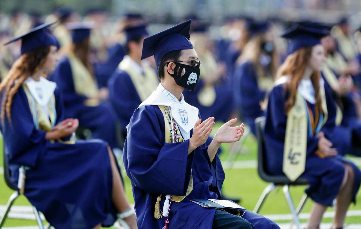 Valedictorian Shaw-Sean Yang, center, claps during a graduation ceremony for Lake Creek High School at MISD Stadium, Thursday, June 4, 2020, in Montgomery. The 220 students in the school's inaugural graduating class attended the outdoor ceremony with social distancing and other safety guidelines. The Montgomery Independent School District is moving forward with the Class of 2021’s indoor graduation plans as the coronavirus pandemic continues.
