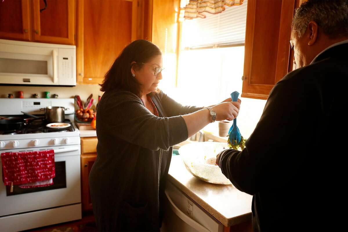 Verónica Hernández, serves lunch to her husband, Juan, at their home in Santa Rosa, Calif., on Thursday, December 17, 2020. Hernández' uncle, José Jesús Arroyo, lost his life to COVID-19 earlier this month.